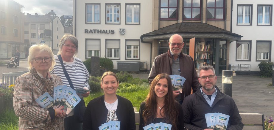 Die Anwesenden der Fairtrade Sitzung mit dem Einkaufsführer vor dem Rathaus