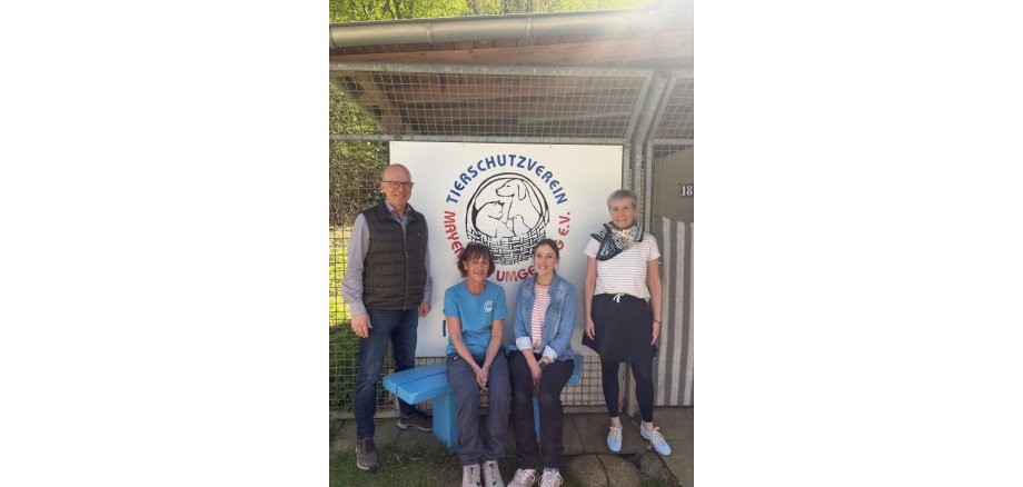 Oberbürgermeister Dirk Meid gemeinsam mit 3 Mitarbeiterinnen des Tierheims vor Logo des Tierheims Mayen