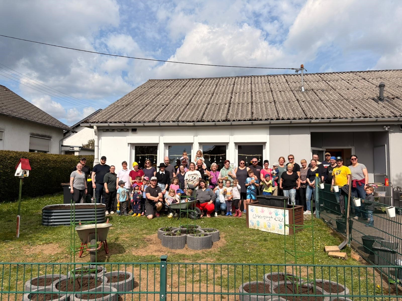 Das Team mit Eltern und Kindern bei den Arbeiten am Naschgarten