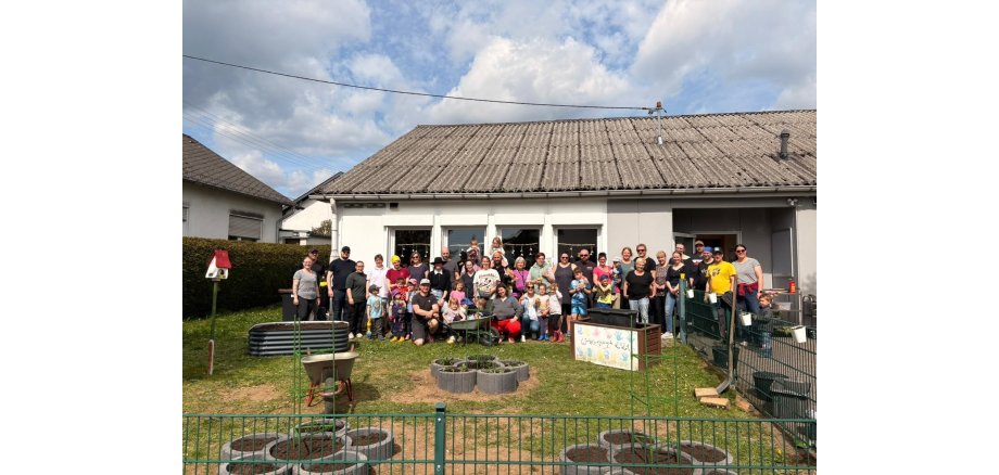 Das Team mit Eltern und Kindern bei den Arbeiten am Naschgarten