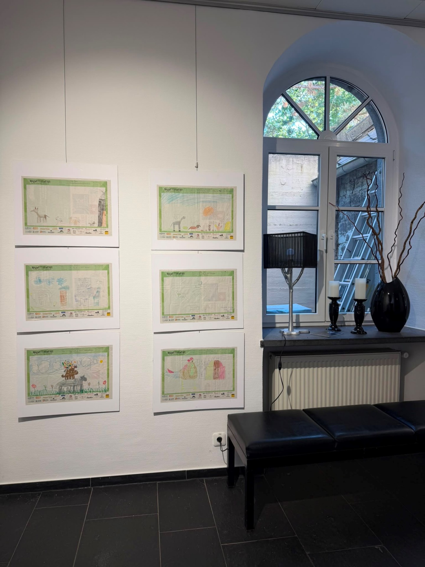 Gemalte Kinderbilder hängen an einer Wand