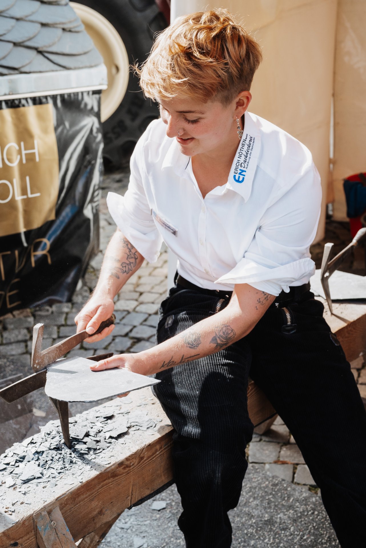 Eine Frau schägt eine Schieferplatte zurecht