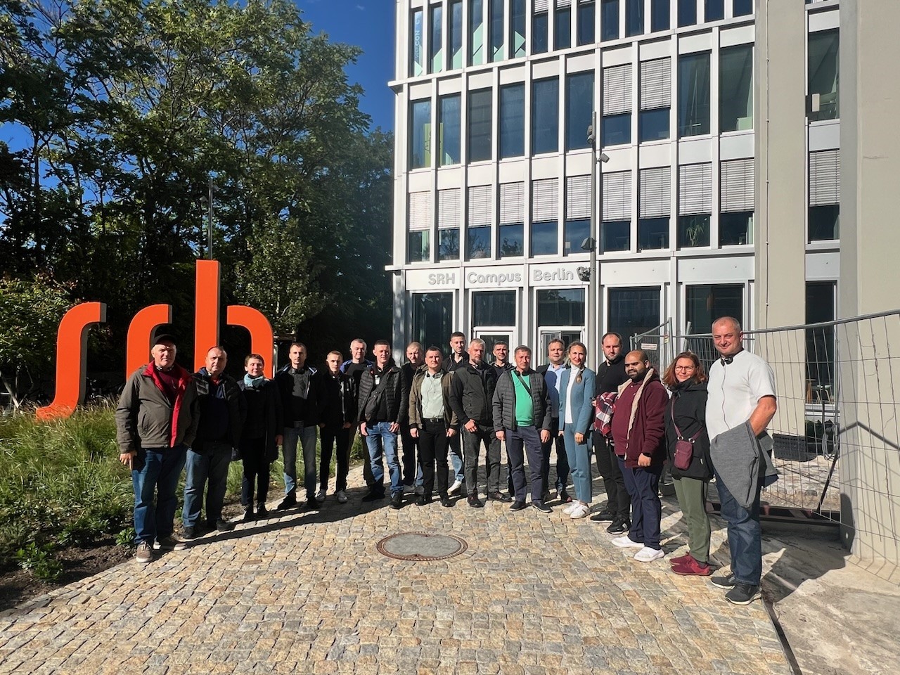 Viele Teilnehmer draußen auf dem SRH Campus in Berlin vor einem Gebäude