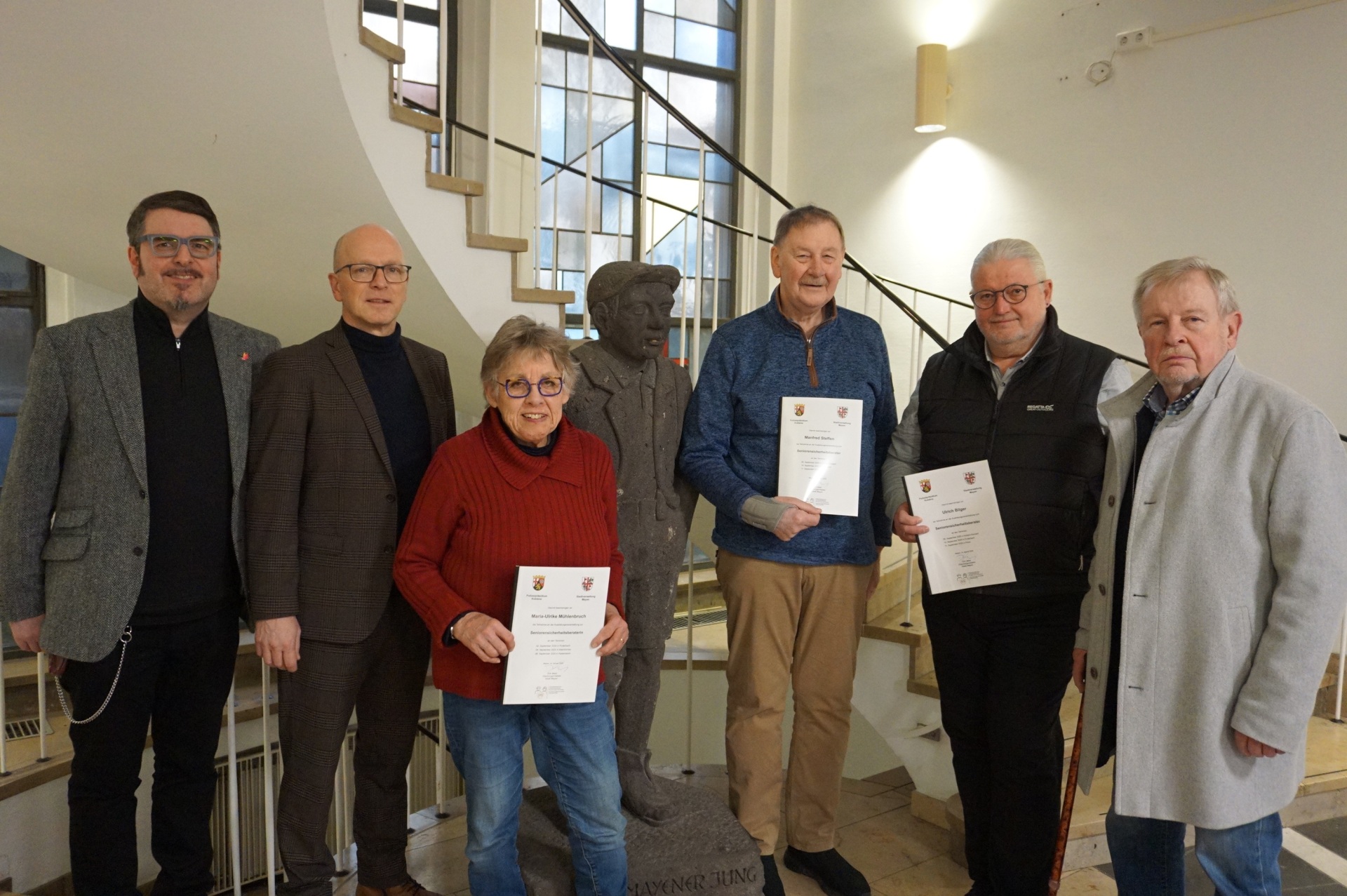 Tobias Härtling, Dirk Meid, Maria-Ulrike Mühlenbruch, Manfred Steffen, Ulrich Bilger und Hans Peter Siewert stehen im Foyer der Stadtverwaltung. Die drei Sicherheitsberater halten jeweils ihre Urkunden in den Händen