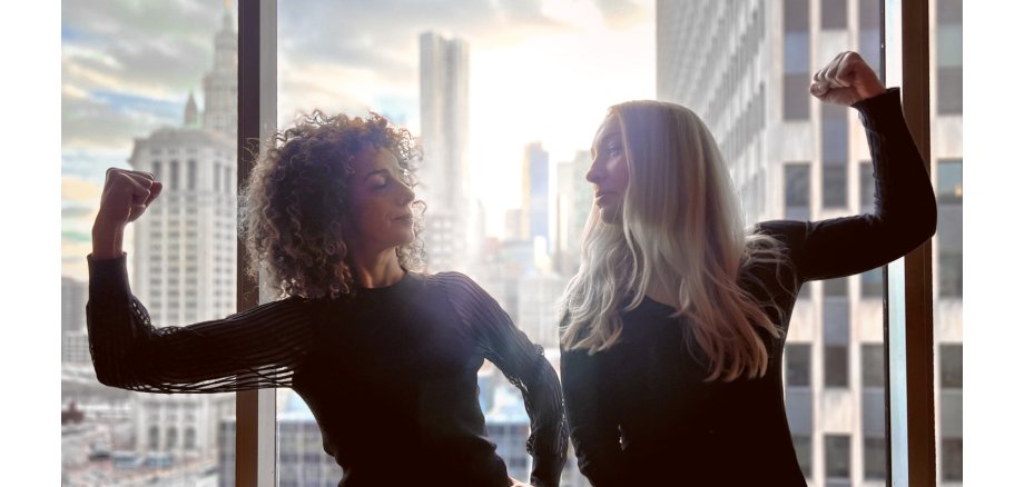 2 Frau schauen sich an - jeweils den Arm im rechten Winkel