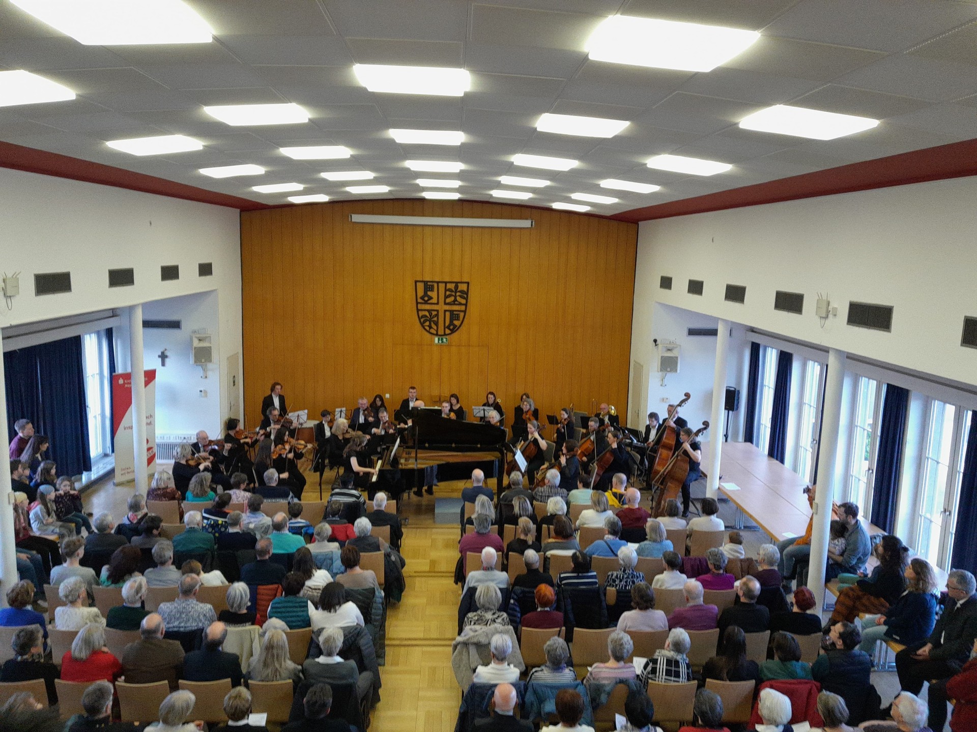 Gefüllter Sitzungssaal. Publikum hört dem Orchester zu