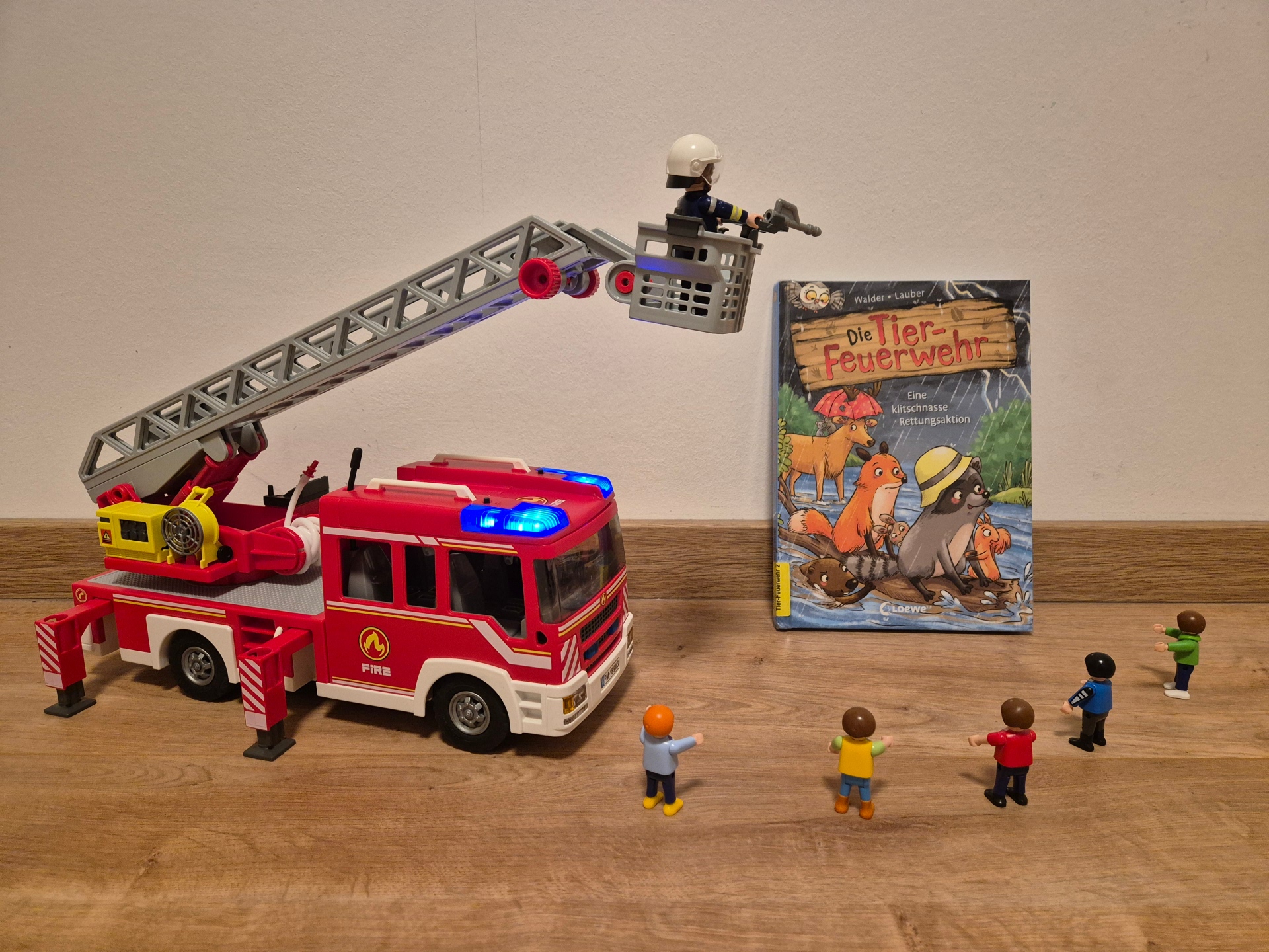 Ein Feuerwehrauto mit einem Buch-Cover und kleinen Personen