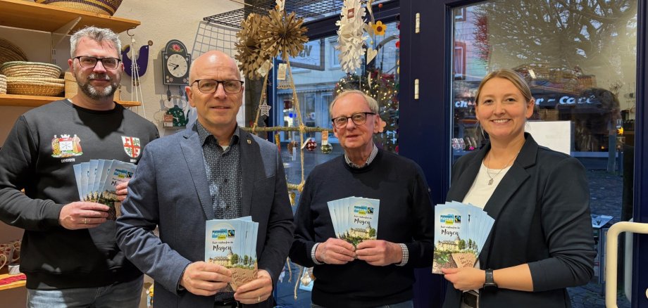 v.l.n.r.: Oliver Schick (Steuerungsgruppe Fairtrade), Oberbürgermeister Dirk Meid, Harald Viehmann (Steuerungsgruppe Fairtrade) und Fairtrade Beauftragte Janine Pitzen freuen sich für die erste Auflage des Einkaufsführers Oliver Schick (Steuerungsgruppe Fairtrade), Oberbürgermeister Dirk Meid, Harald Viehmann (Steuerungsgruppe Fairtrade) und Fairtrade Beauftragte Janine Pitzen stehen nebeneinander im eine Welt Laden und halten gemeinsam jeweils einen Flyer in der Hand