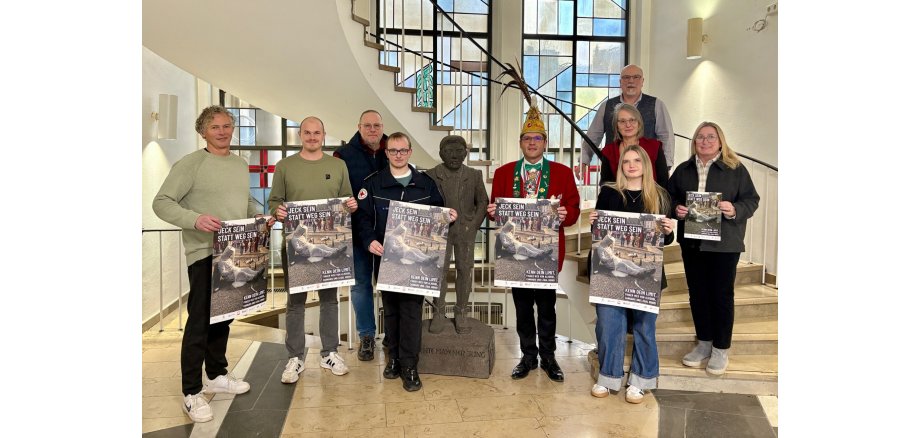 Die Kooperationspartnerinnen und -partner sowie Sponsoren präsentieren stehen im Foyer der Stadtverwaltung und halten das neue Plakat zur diesjährigen Jugendschutzkampagne in den Händen