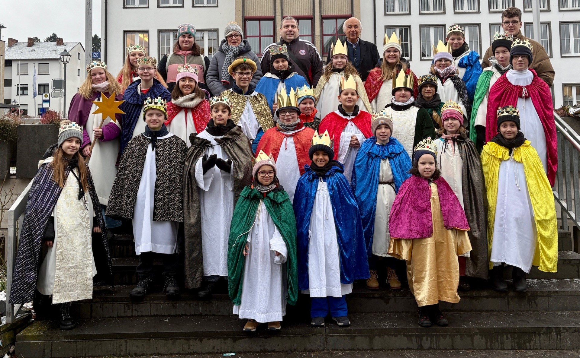Viele als Sternsinger verkleidete Kinder stehen auf der Treppe vor der Stadtverwaltung