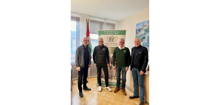 Oberbürgermeister Dirk Meid, Bernhard Sommer, Vorsitzender der VOR-TOUR der Hoffnung, Stellvertreter Hans-Josef Bracht und Bürgermeister Bernhard Mauel stehen nebeneinander vor einem Rollup
