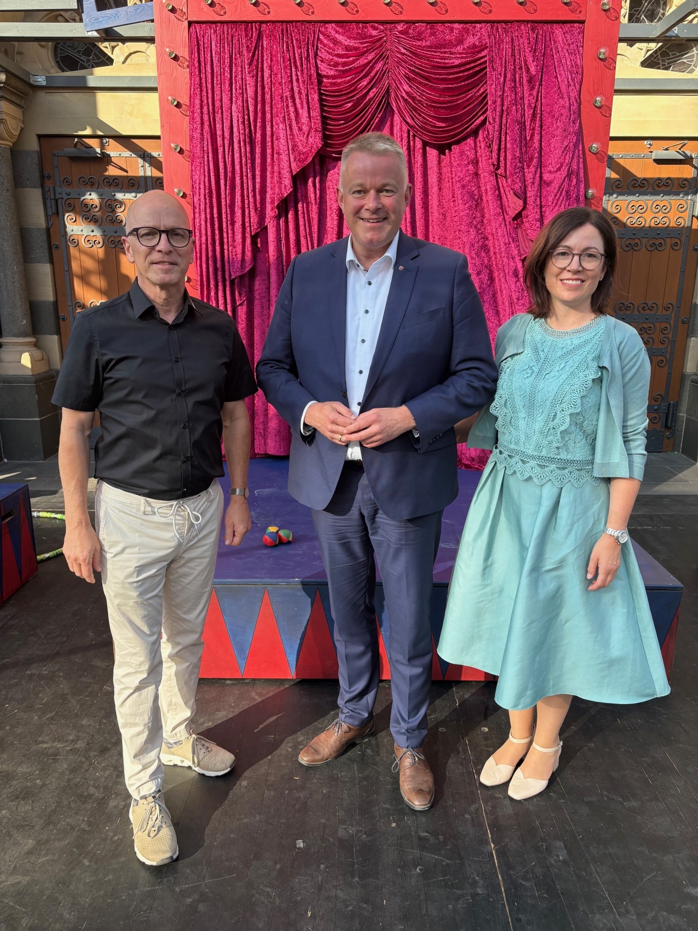 Oberbürgermeister Dirk Meid, Ministerpräsident Gordon Schnieder und Ehefrau Diane Schnieder stehen gemeinsam auf der Bühne der Burgfestspiele