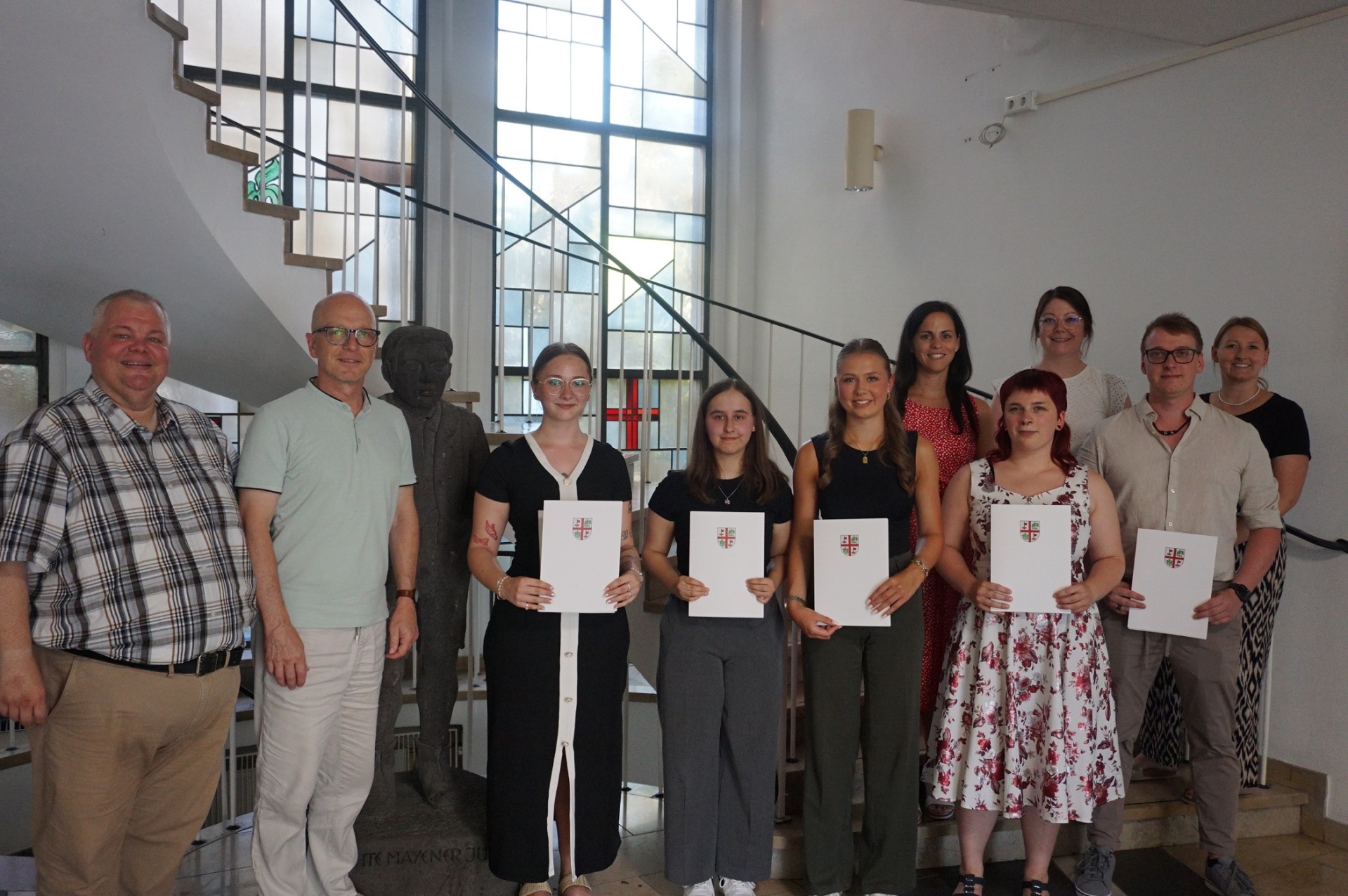 Wolfgang Goeken, Dirk Meid, Jasmin Alter, Sabrina Retterath und Janine Pitzen stehen gemeinsam mit den neuen Anwärtern im Vorraum der Stadtverwaltung