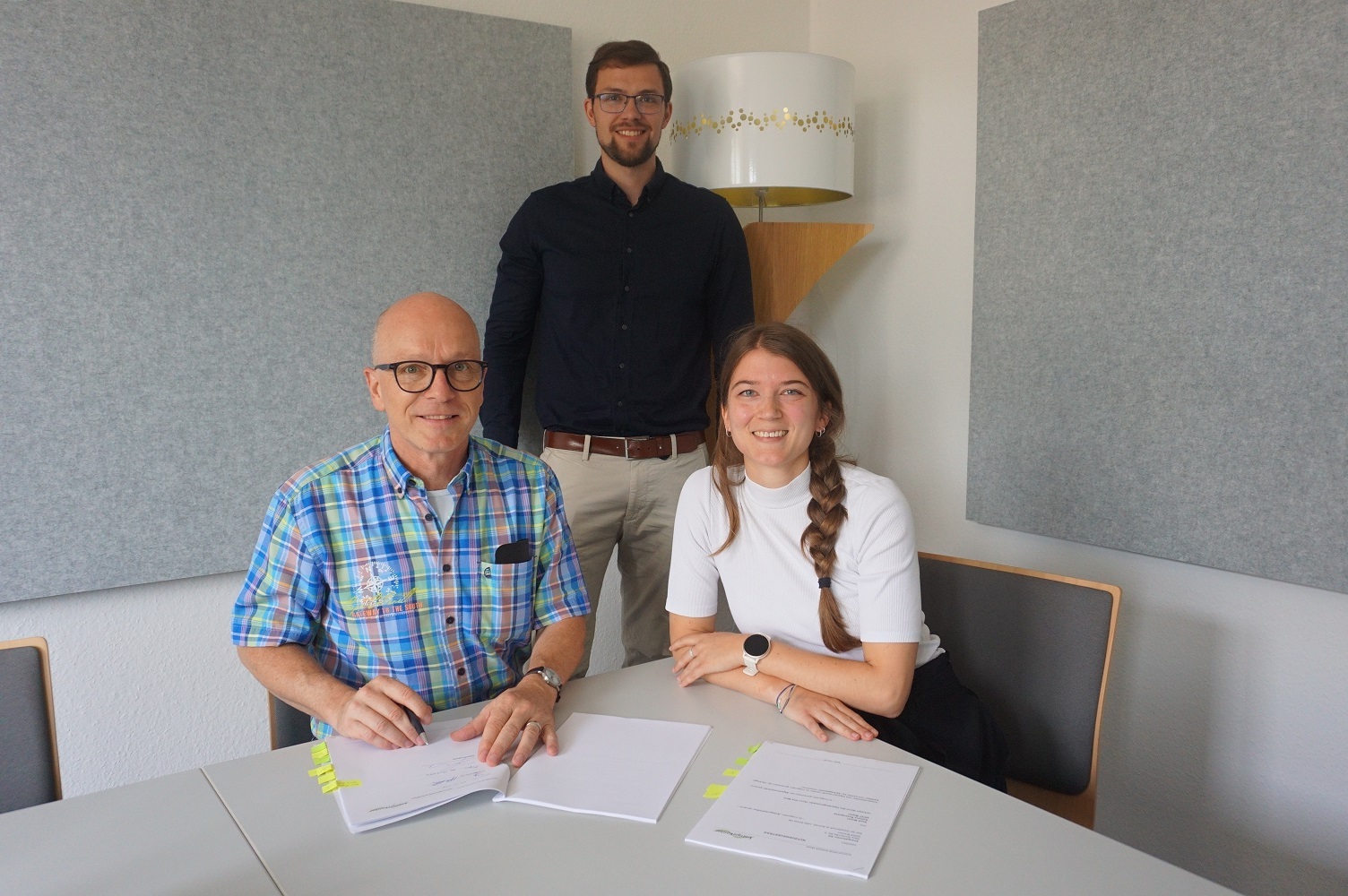 3 Personen bei der Vertragsvereinbarung