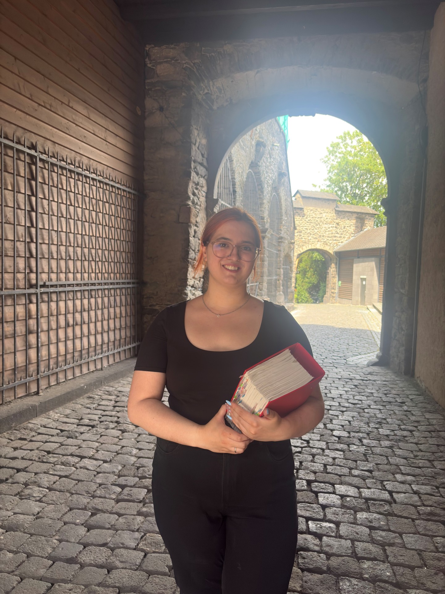 Pauline Montada hat ein dickes Buch in der Hand und steht im Tunnel an der Genovevaburg