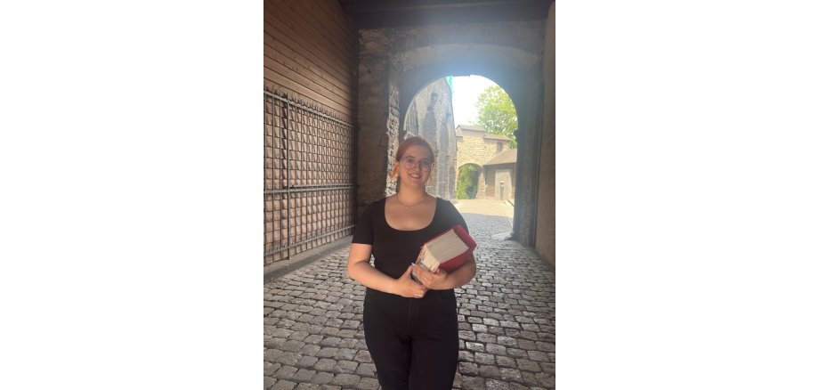 Pauline Montada befindet sich im zweiten Ausbildungsjahr zur Stadtsekretärin und gibt Einblicke in ihre vielseitige Ausbildung bei der Stadt Mayen Pauline Montada hat ein dickes Buch in der Hand und steht im Tunnel an der Genovevaburg