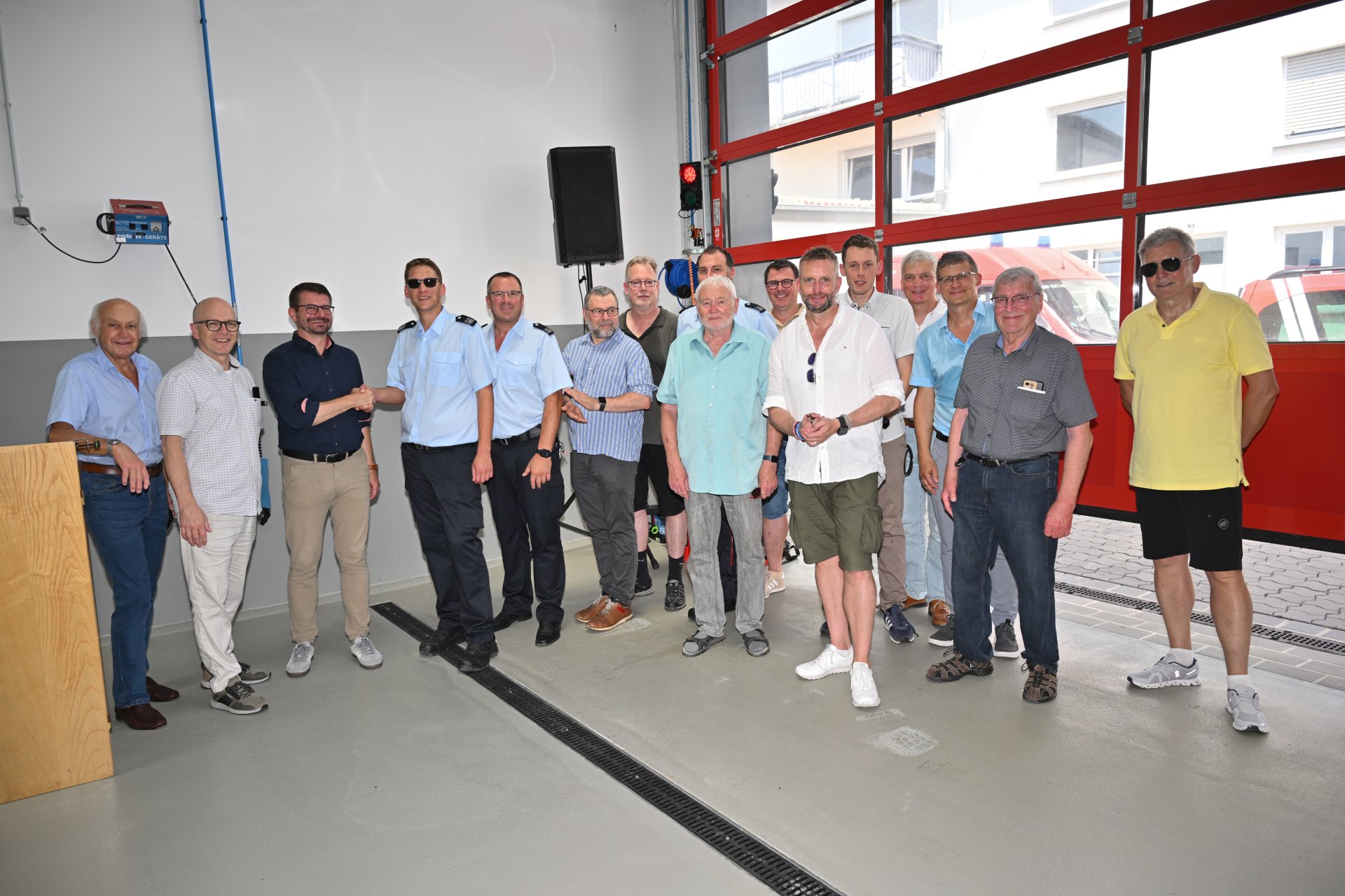 Viele Menschen stehen gemeinsam im neuen Feuerwehrgerätehaus