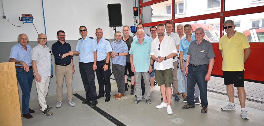 Feierliche Einweihung des Feuerwehrgerätehauses Viele Menschen stehen gemeinsam im neuen Feuerwehrgerätehaus