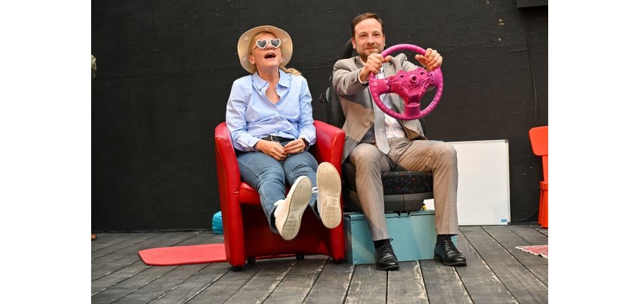Lesung zu „Achtsam Morden“ am 25. Juni Zwei Schauspieler sitzen auf Sesseln auf der kleinen Bühne im Arresthaus