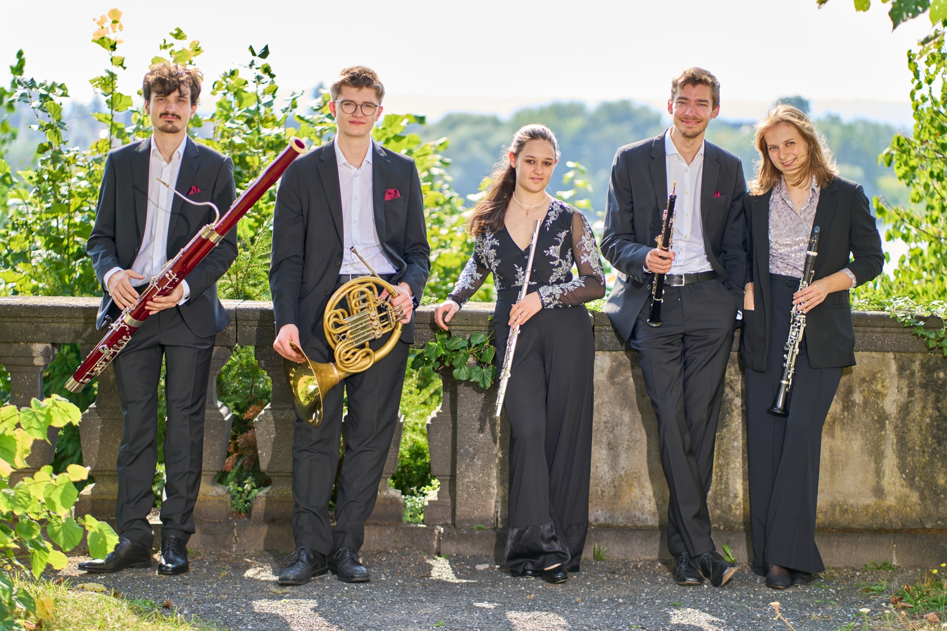 Ensemble Quinton steht draußen. Fünf Personen die jeweils ein Instrument in der Hand halten
