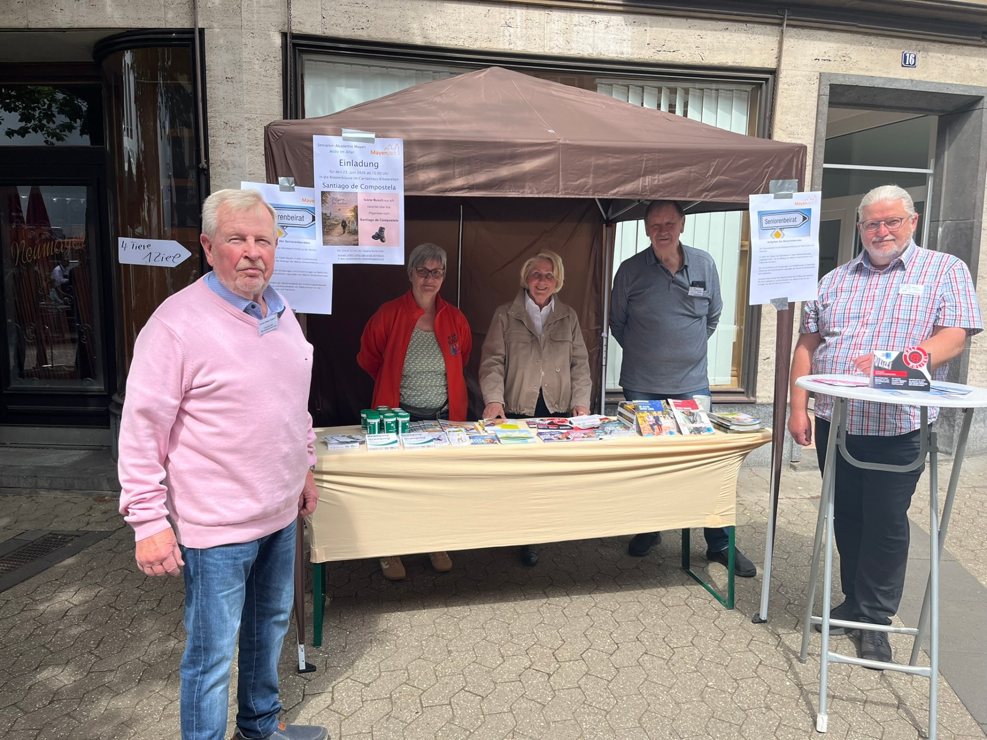 Fünf Menschen stehen draußen in der Brückenstraß an ihrem Stand