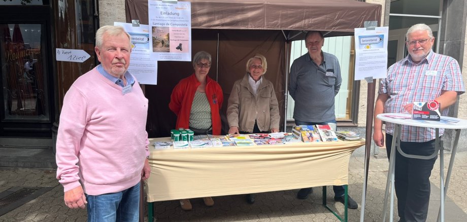Fünf Menschen stehen draußen in der Brückenstraß an ihrem Stand