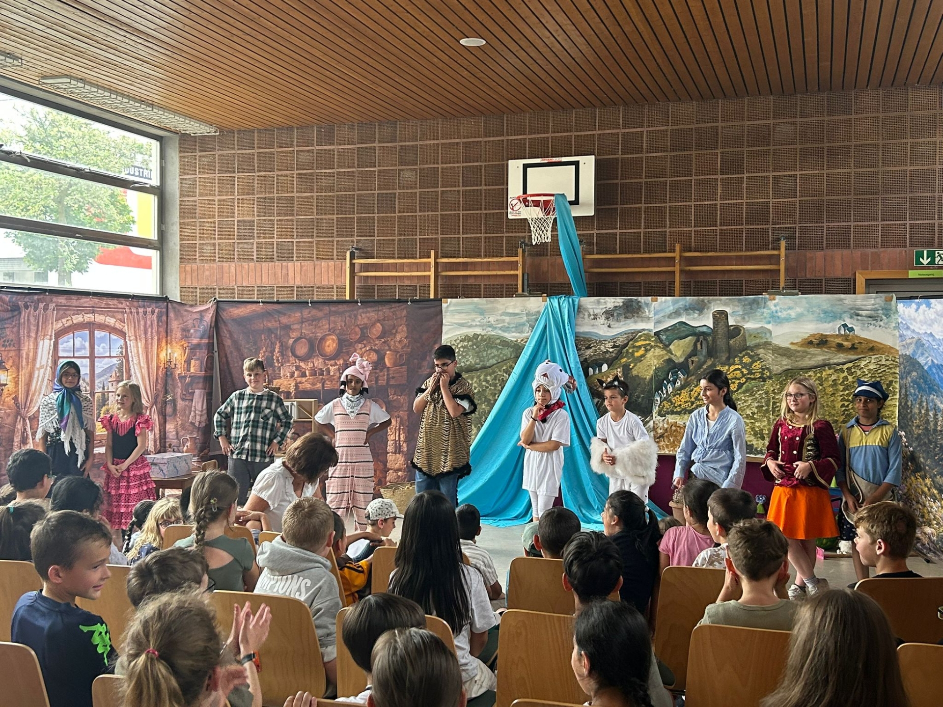 Viele verkleidetet Kinder stehen vor einem bunten Bühnenbild