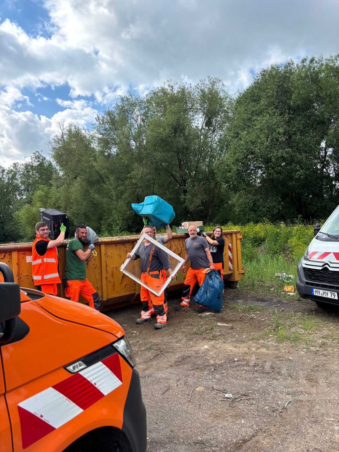 Mitarbeiter des Betriebshofs werfen Müll in einen Container