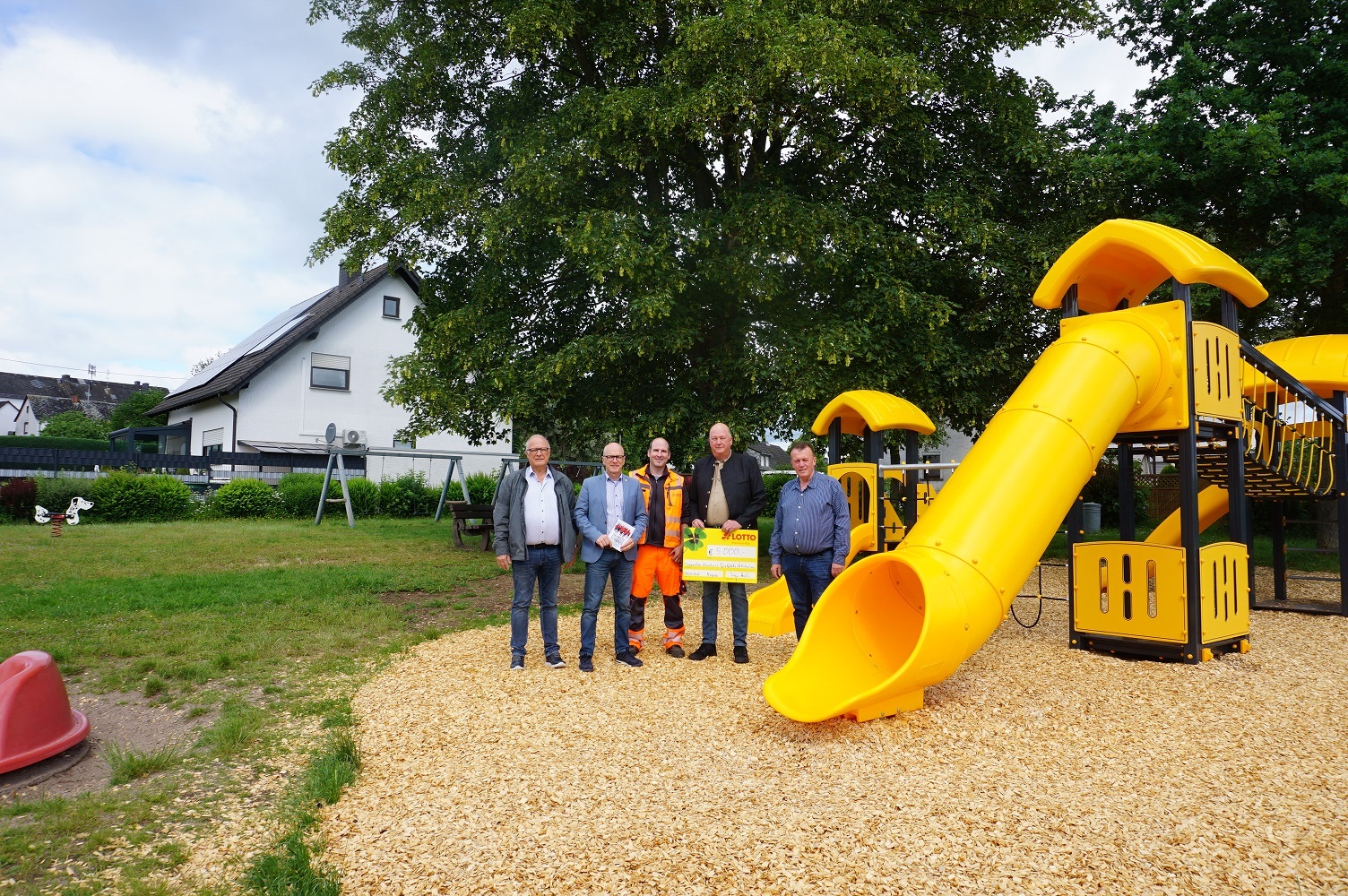 Ortsvorsteher Lothar Geisen, Oberbürgermeister Dir Meid, Spielplatzprüfer Stefan Schneider, 1. Vorsitzender Michael Schmitt und Bereichsleiter Horst Helmes stehen in Alzheim auf dem Kinderspielplatz vor einem Klettergerüst