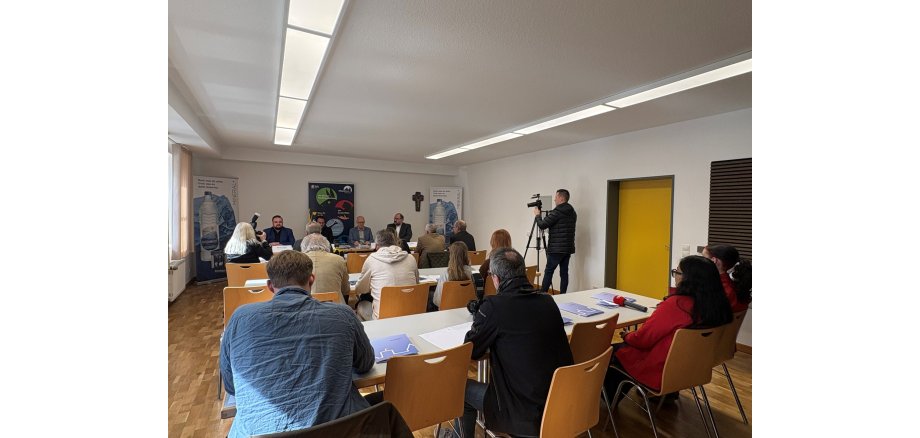 Die diesjährige Pressekonferenz der Burgfestspiele fand in diesem Jahr im Lukas Haus statt Mehrere Menschen sitzen in einem Raum und hören Sprechern zu