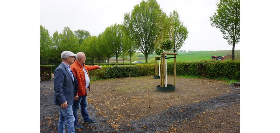 OB Meid und Ortsvorsteher Geisen stehen gemeinsam auf dem Friedhof in ALzheim und schauen sich die Arbeiten an 