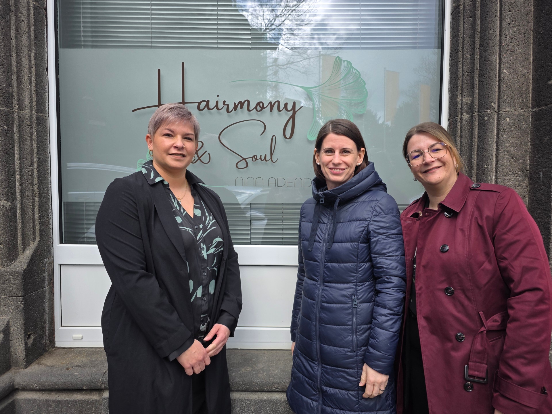 Nina Adendorf, Christina Wolff (Wirtschaftsförderung), Linda Greger (My-Gemeinschaft) stehen vor dem Schaufenster von Hairmony & Soul