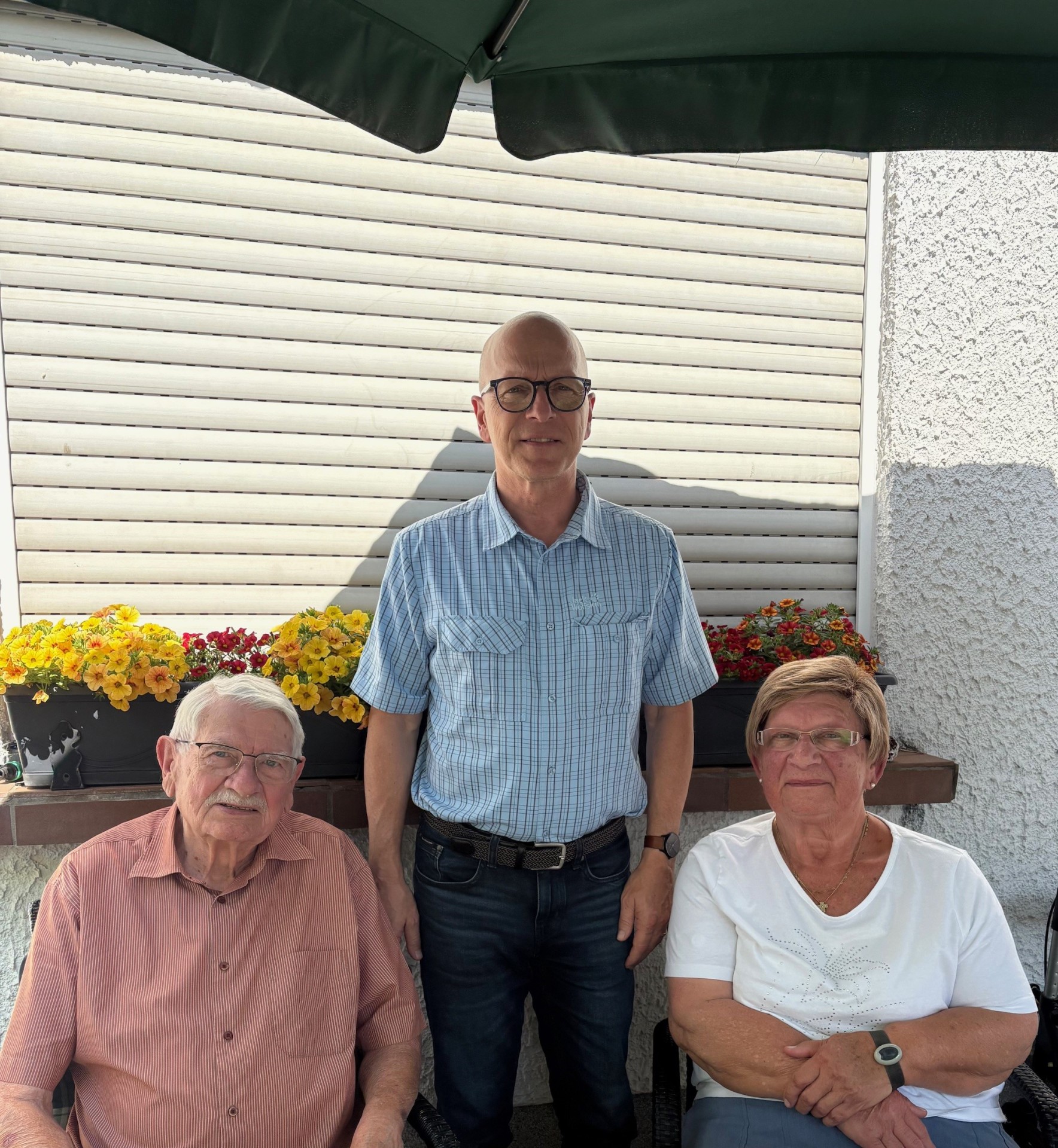 Zwei Männer und eine Frau stehen für ein Foto zusammen