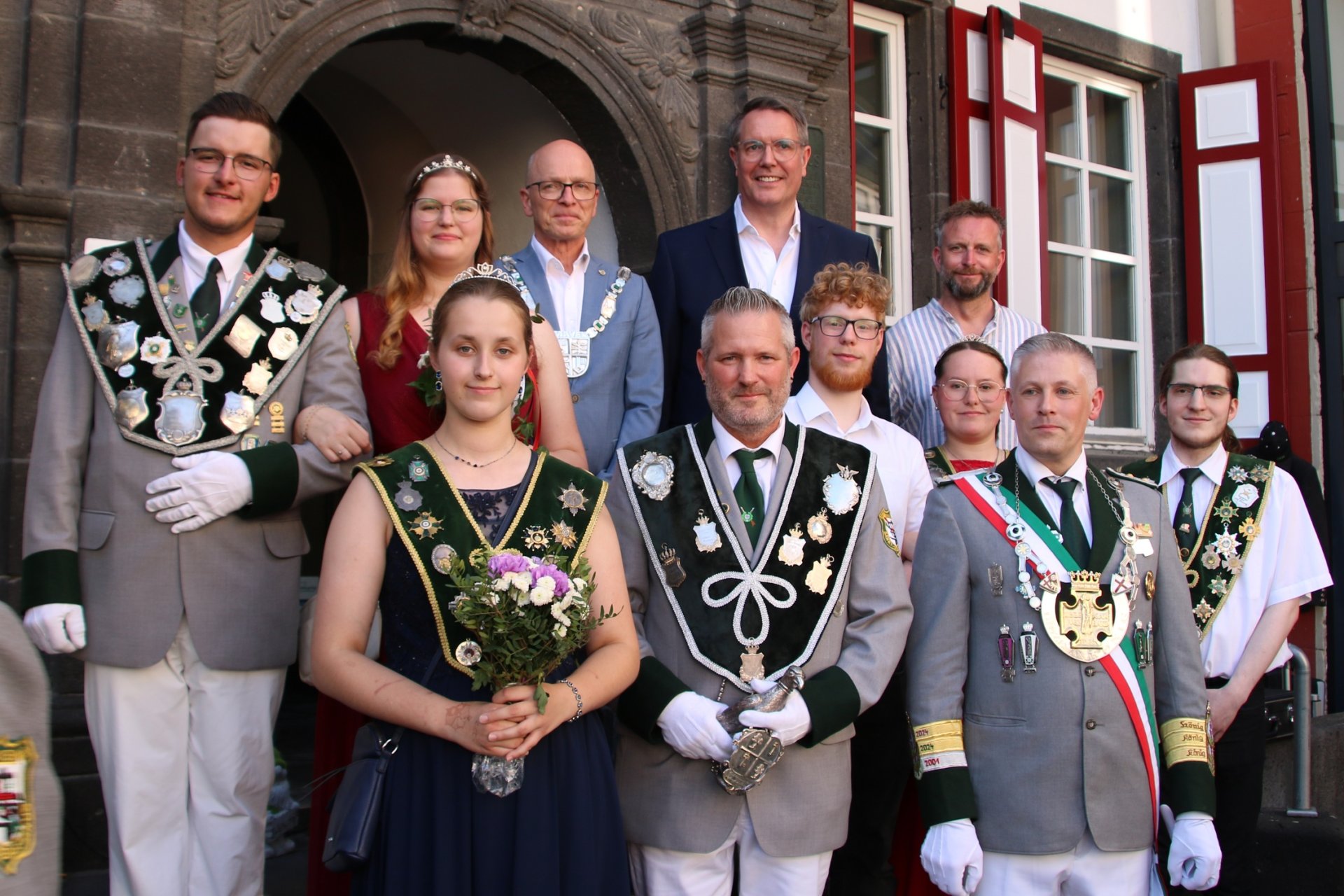 Schützen stehen gemeinsam mit Oberbürgermeister Dirk Meid, Landrat Marko Boos und Ministerpräsident Alexander Schweitzer stehen gemeinsam auf der Treppe vor dem Alten Rathaus