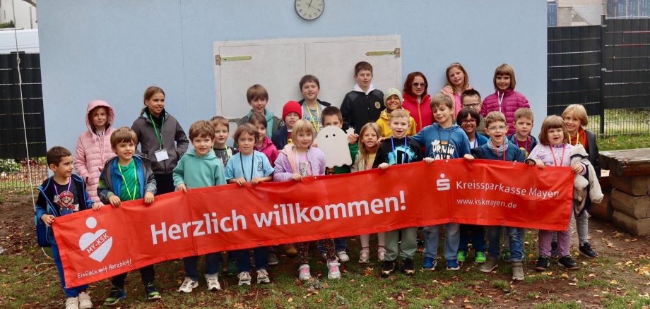 Die Kinder genossen ihre Zeit in Genovevia Viele Kinder mit einem Banner vor dem Jugendhaus