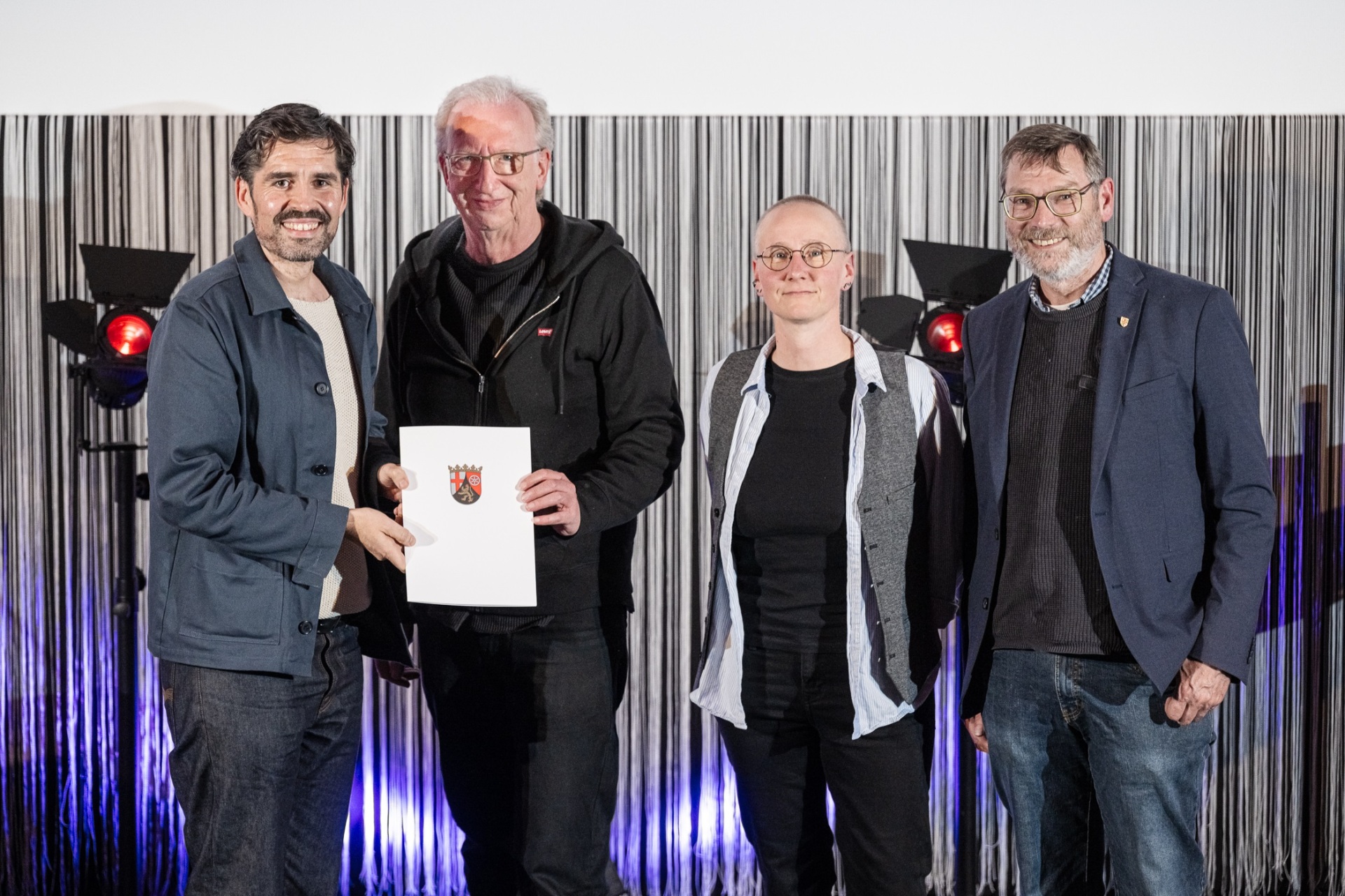 4 Personen stehen für ein Foto zusammen