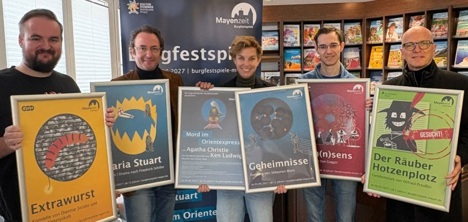 v.l.n.r.: Verwaltungsleiter Kevin Stoye, Intendant Alexander May, stellvertretende Intendantin Caroline Stolz, Philipp Beyl vom Reisebüro Bell und Oberbürgermeister Dirk Meid freuen sich auf die kommende Spielzeit 5 Personen mit Plakaten