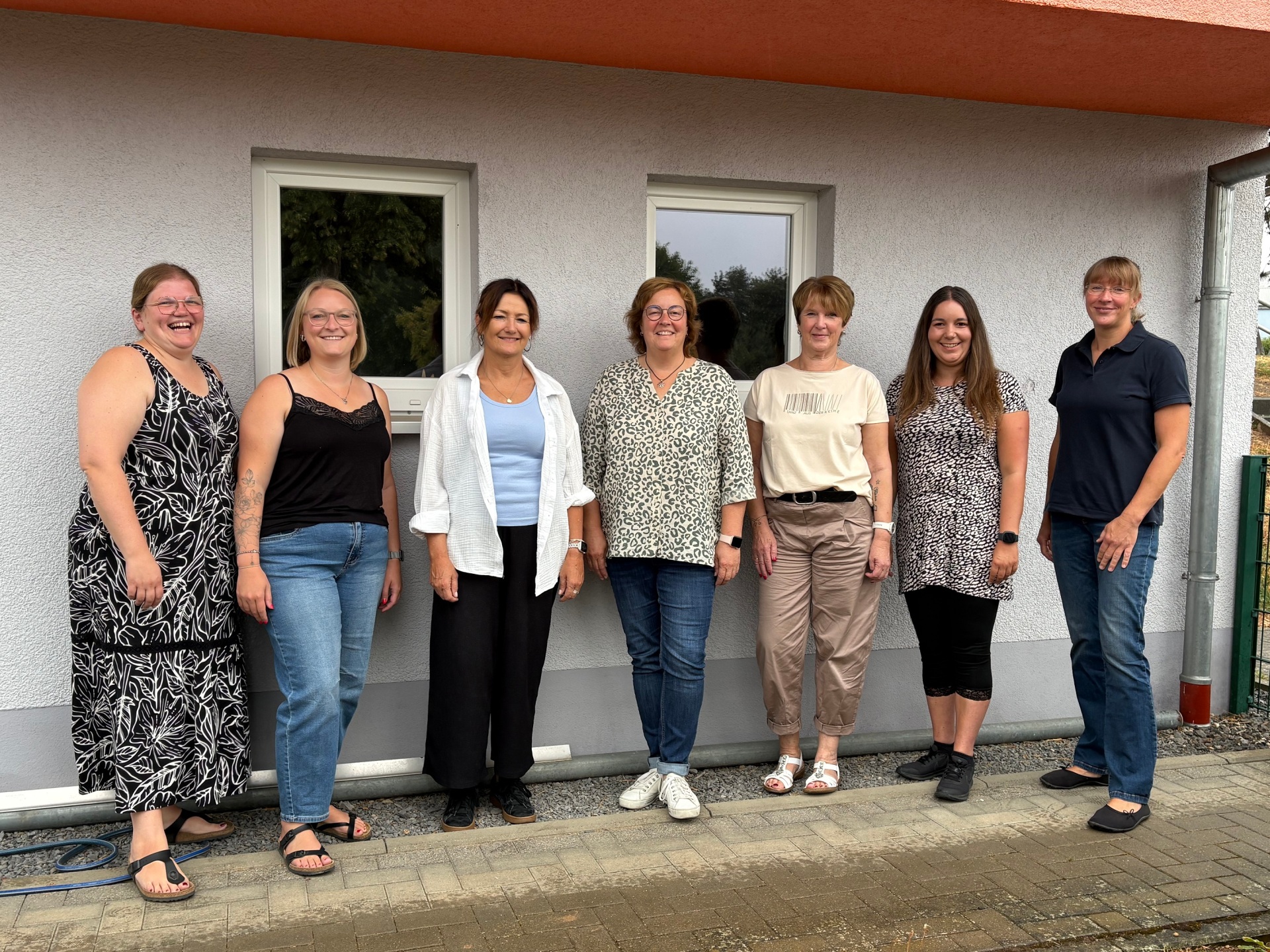 Sieben Frauen stehen für ein Foto zusammen