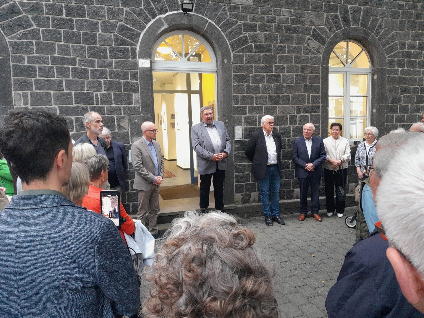 Viele Besucher im Kreis aufgestellt im Innenhof des Arresthaus