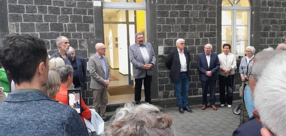 Zahlreiche Besucherinnen und Besucher kamen zur Ausstellungseröffnung Viele Besucher im Kreis aufgestellt im Innenhof des Arresthaus