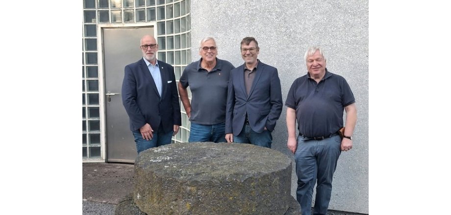 v. l. n. r.: Uwe Hoffmann, Fachbereichsleiter 1, Hans Schüller, Vorsitzender GAV, Thomas Schröder, Beigeordneter, Dr. Stefan Wenzel, LEIZA, Referent des Abends stehen hinter einem Mühlstein