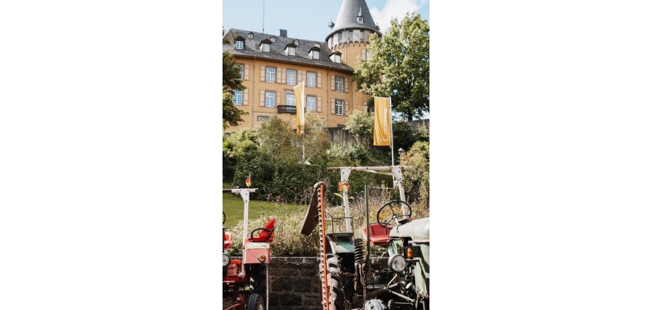 Ein Oldtimer Traktor steht vor der Burg