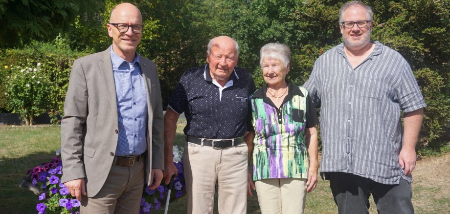 Vier Menschen darunter Oberbürgermeister Dirk Meid stehen draußen in der Sonne auf einer Wiese