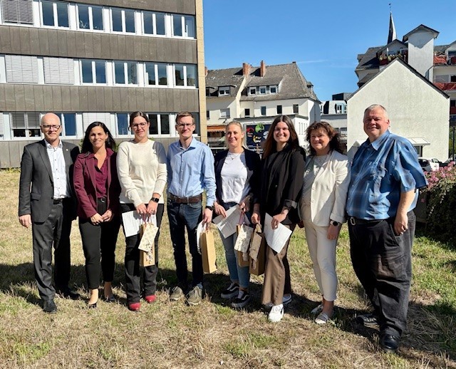 8 Personen stehen für ein Foto zusammen