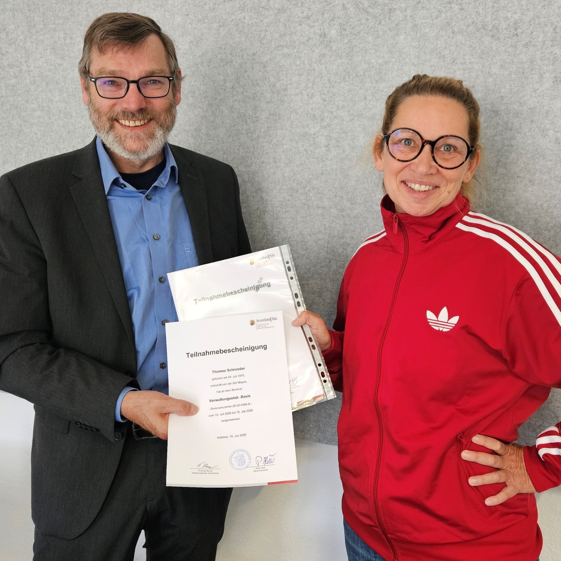 Ein Mann und eine Frau halten eine Urkunde in der Hand