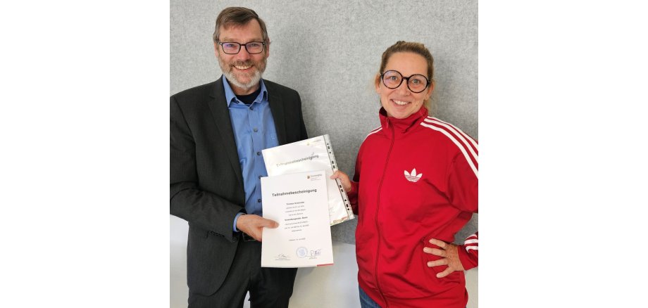 Ein Mann und eine Frau halten eine Urkunde in der Hand