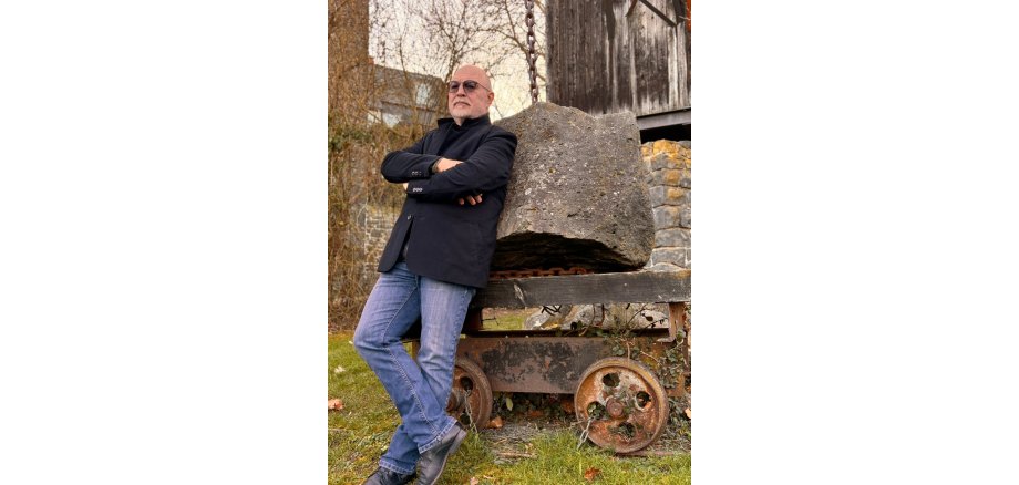 Wilfried Manheller, zu erleben bei seiner Lesung am 06. Oktober in Mayen Wilfried Manheller lehnt sich gegen einen Stein
