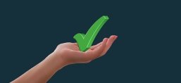 Ein grünes Häkchen wird von einer Hand gehalten.