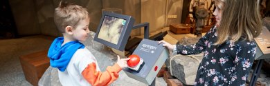 Foto Behrendt Kinder drücken im Museum auf einen roten Knopf