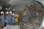 Familie im Schieferbergwerk mit einem Bagger